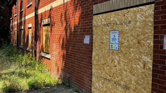 An emergency borded up building with Marpol signage