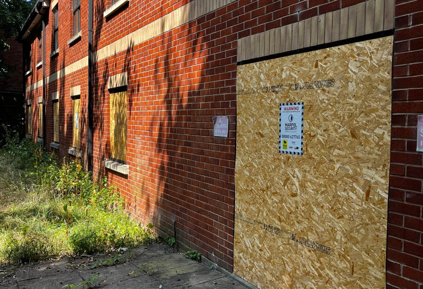 An emergency borded up building with Marpol signage