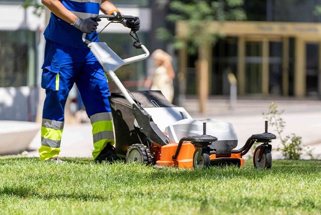 Grounds maintenance - A gardener mowing the grass