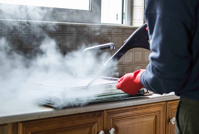 A pest control worker in action on a sink